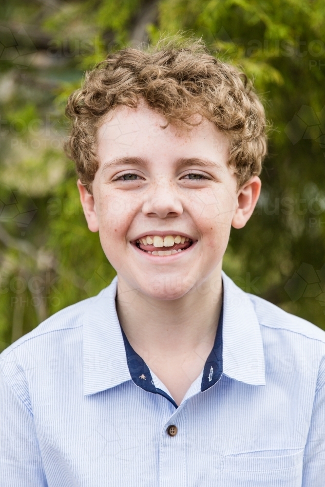 Young child with curls outside smiling happy - Australian Stock Image