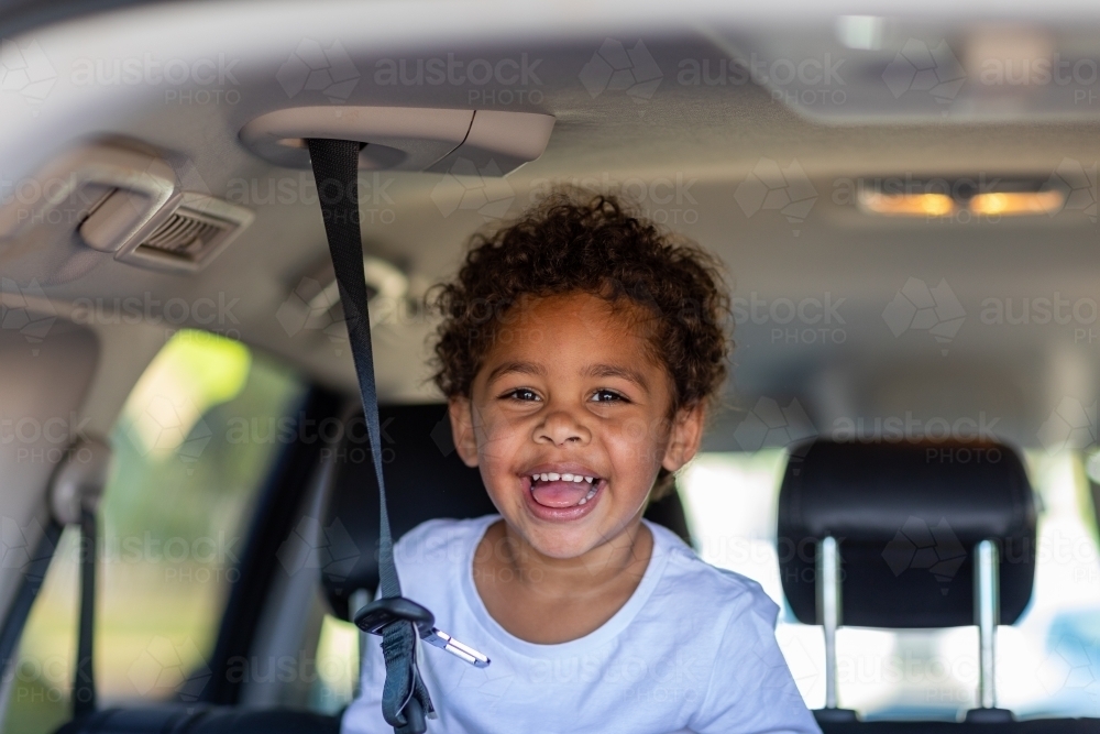 young child with seatbelt strap in back of station wagon - Australian Stock Image