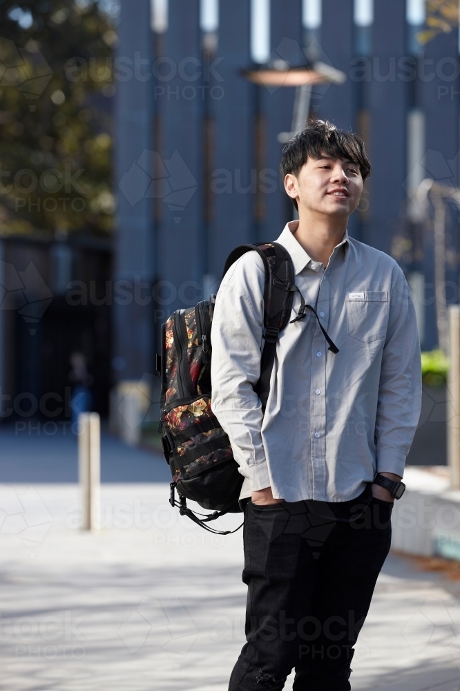 Young Chinese student outdoors with backpack - Australian Stock Image