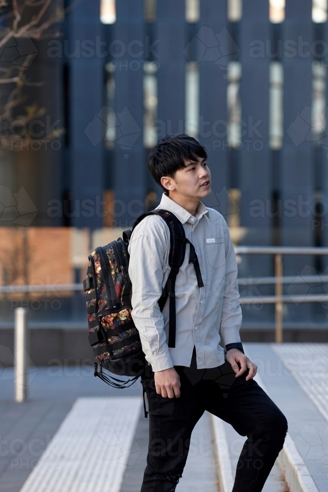 Young Chinese student walking on stairs at university campus - Australian Stock Image