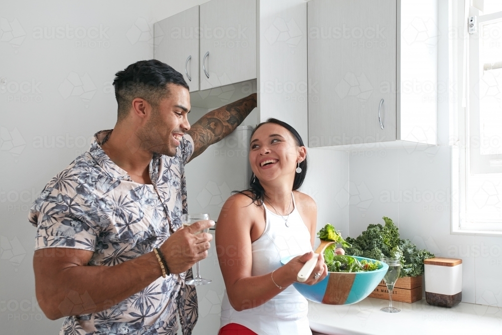 Young couple cooking in kitchen together - Australian Stock Image