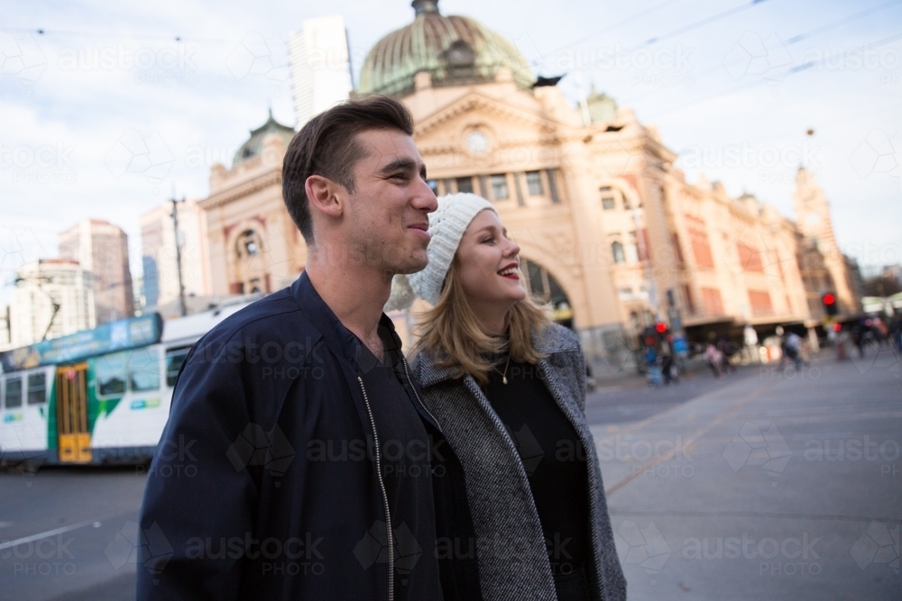 Young Couple Crossing Flinders Street in Winter - Australian Stock Image