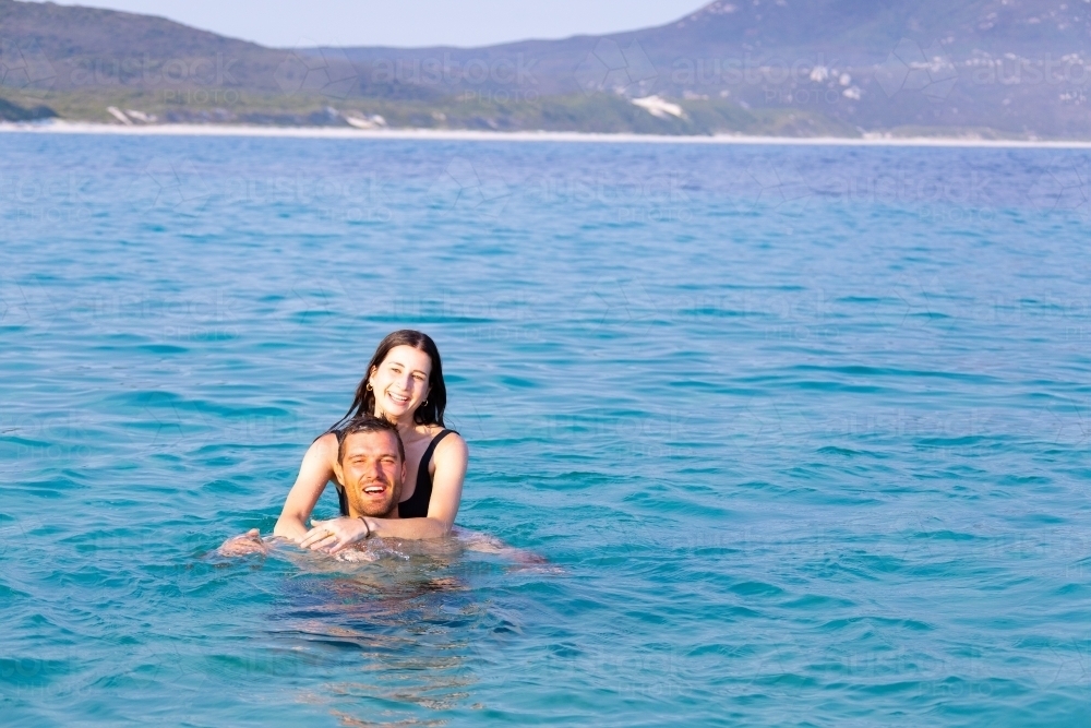 young couple enjoying cooling off in the ocean on a hot day - Australian Stock Image
