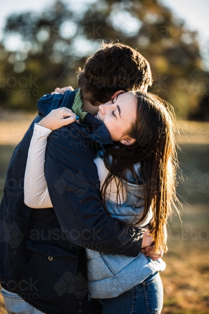 Young couple giving each other a big cuddle - Australian Stock Image