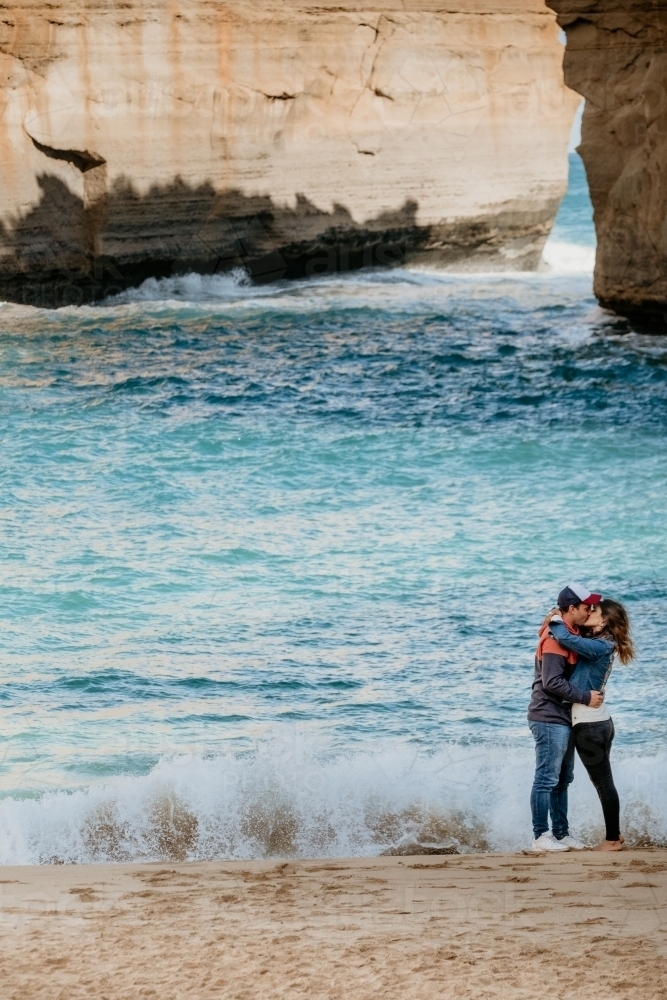 Young couple kiss at tourist beach. - Australian Stock Image