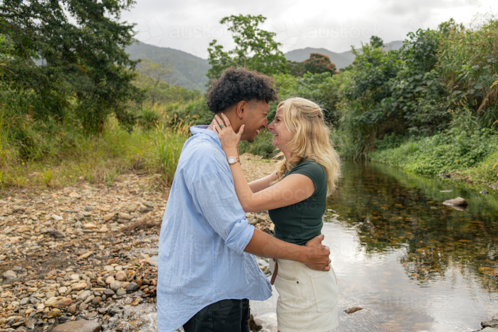 Young couple laughing and embracing at a creek in far north Queensland - Australian Stock Image