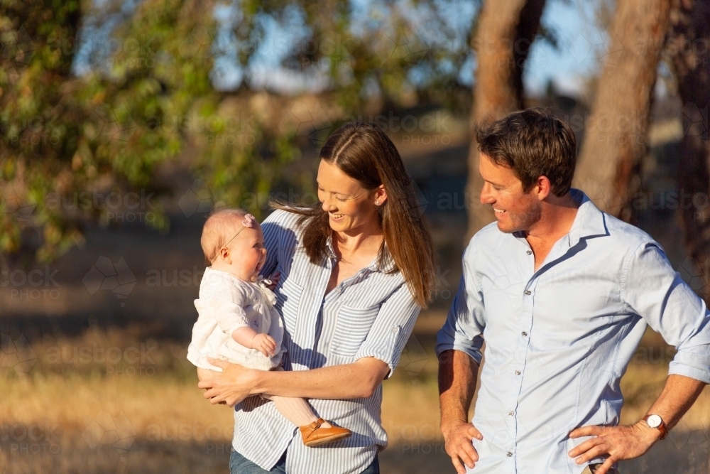 Young couple outdoors with their baby girl in the sunshine - Australian Stock Image