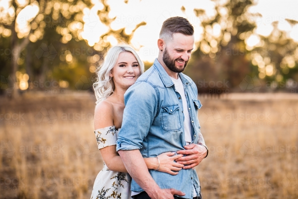 Premium Photo  A young man hugs a girl by the waist couple standing with  their backs to the camera