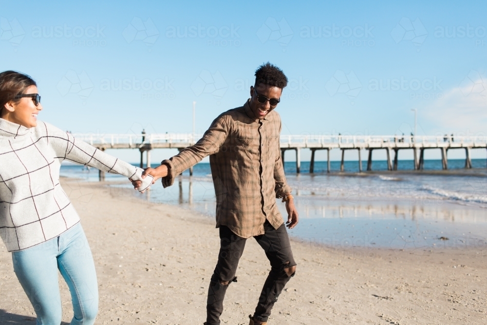 Young couple walking together on the beach - Australian Stock Image
