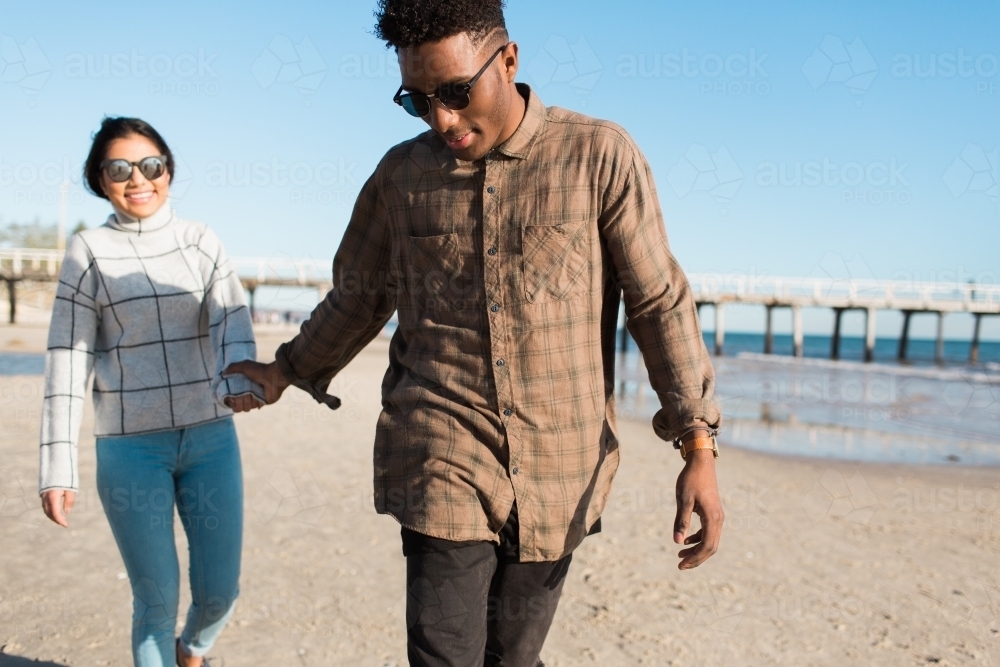 Young couple walking together on the beach - Australian Stock Image