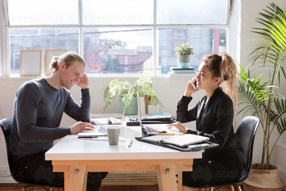 Young creatives working at a desk in a studio : Austockphoto Young creatives working at a desk in a studio - Australian Stock Image