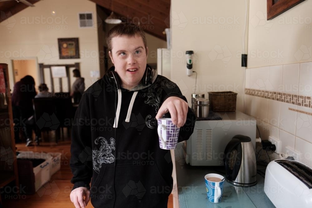 Young Disabled Man Serving a Cup of Coffee - Australian Stock Image