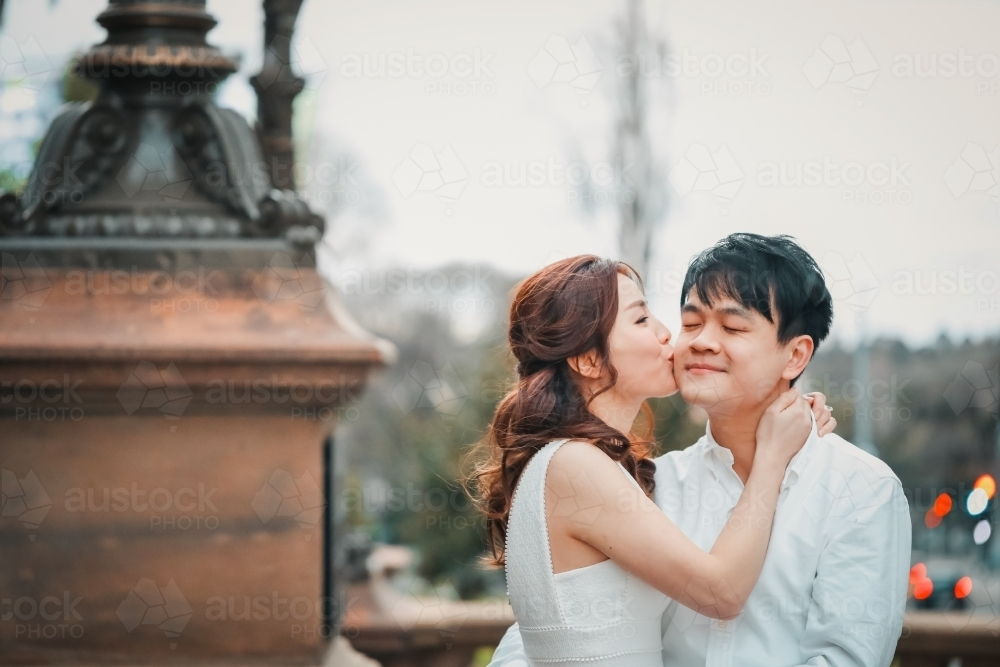 Young engaged couple embracing on the steps of the Old Treasury Building in Melbourne - Australian Stock Image