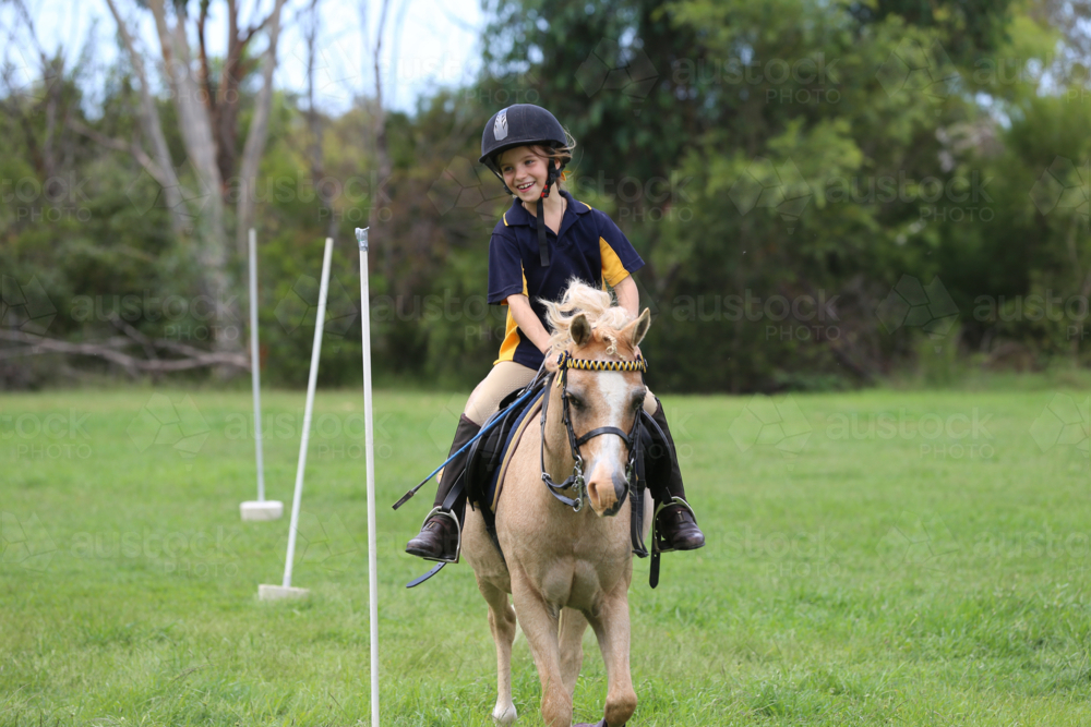 Young equestrian rider on a light-coloured horse - Australian Stock Image