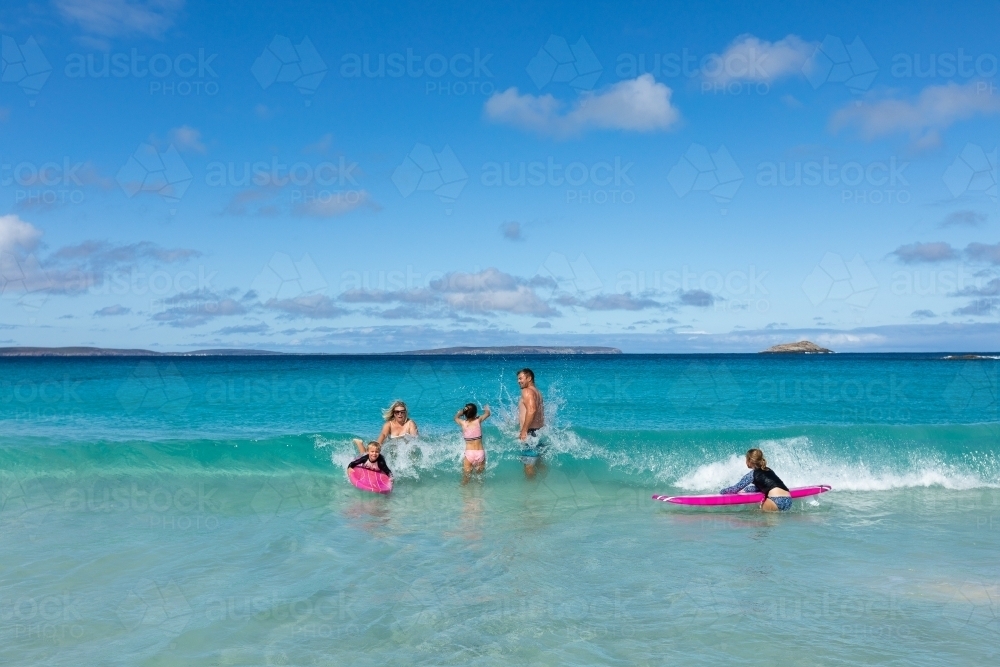 young family having fun in the surf - Australian Stock Image