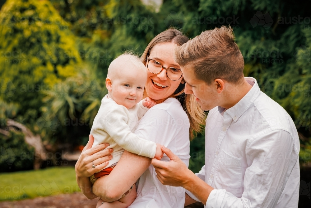 Young family of 3 with small baby at the park - Australian Stock Image