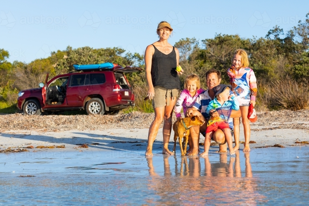 Young family posing in a group at the beach - Australian Stock Image