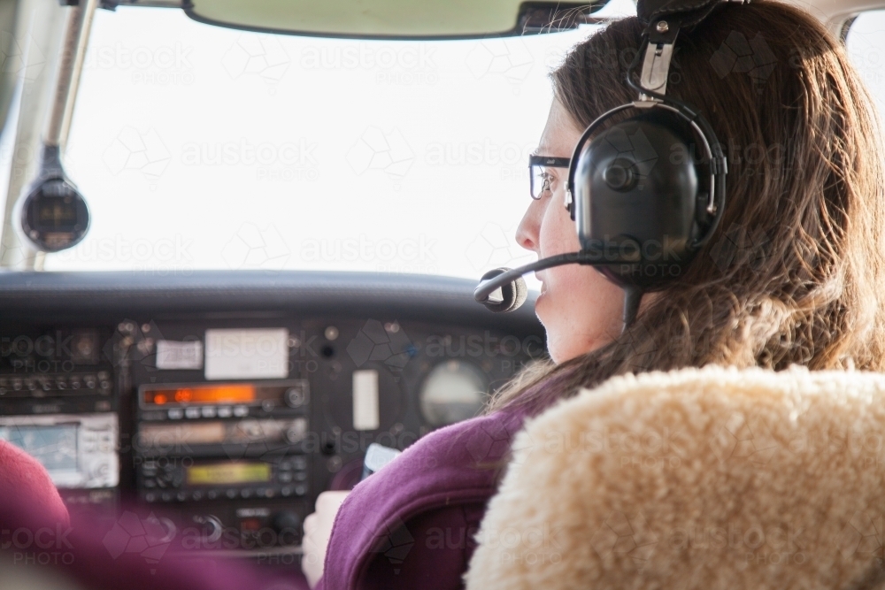 Young female adult flying a plane from the copilot seat - Australian Stock Image