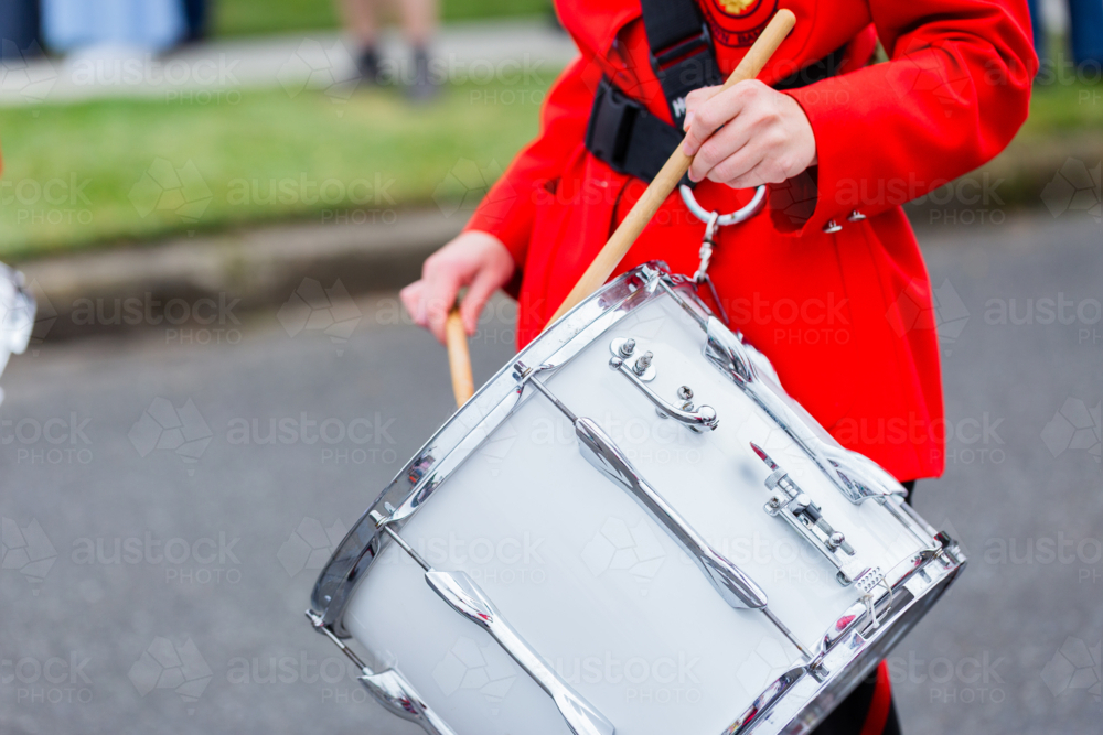 Young female drummer playing in local band during ANZAC day parade march - Australian Stock Image