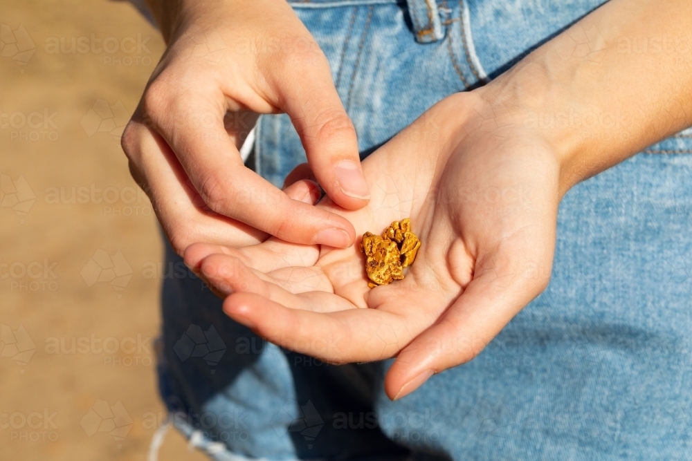 young female hands holding gold nugget - Australian Stock Image