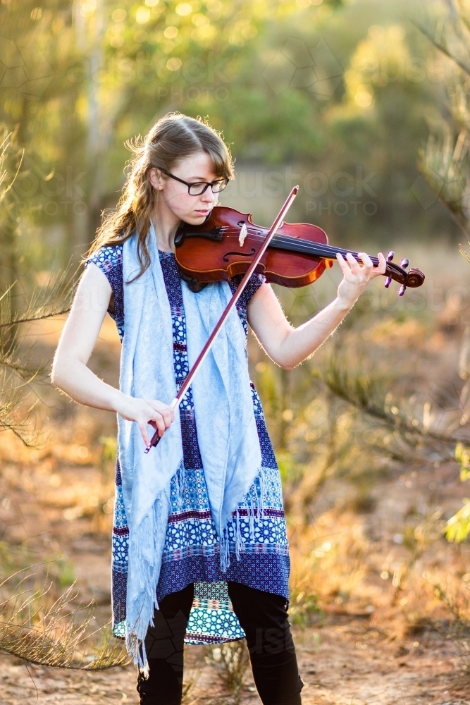 Young female musician playing her instrument outside - Australian Stock Image