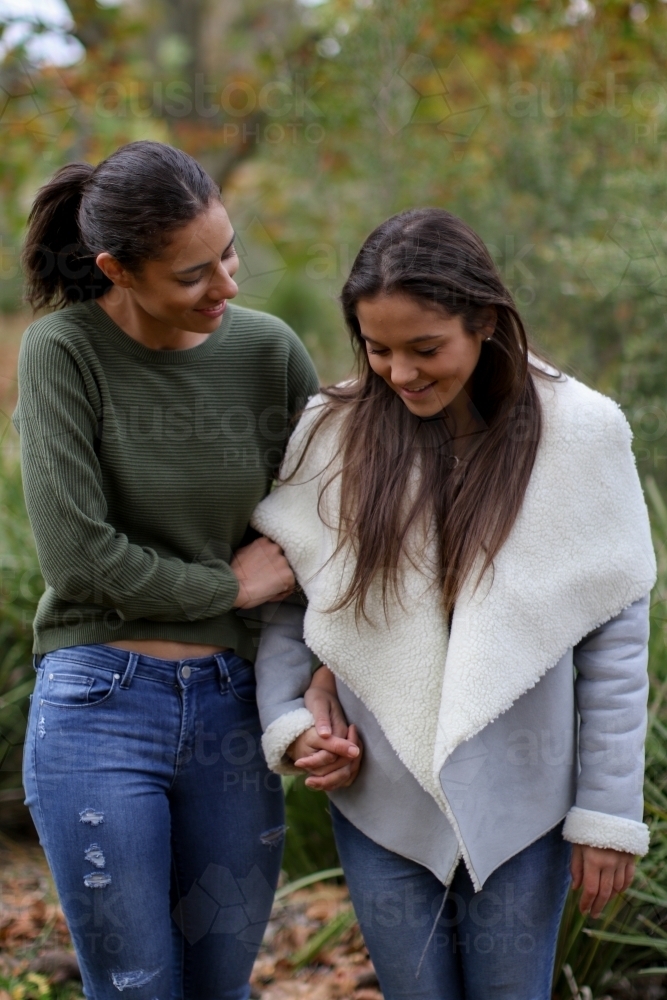 Young female same sex couple walking hand in hand - Australian Stock Image