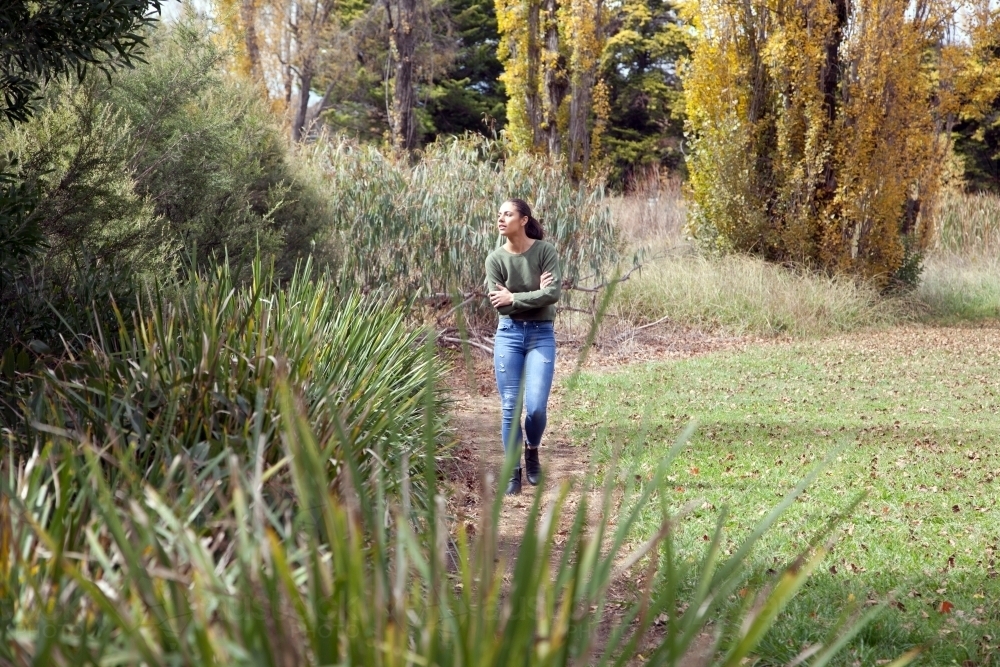 Young female walking alone in a park - Australian Stock Image