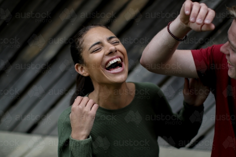 Young Fijian woman throwing head back with laughter - Australian Stock Image