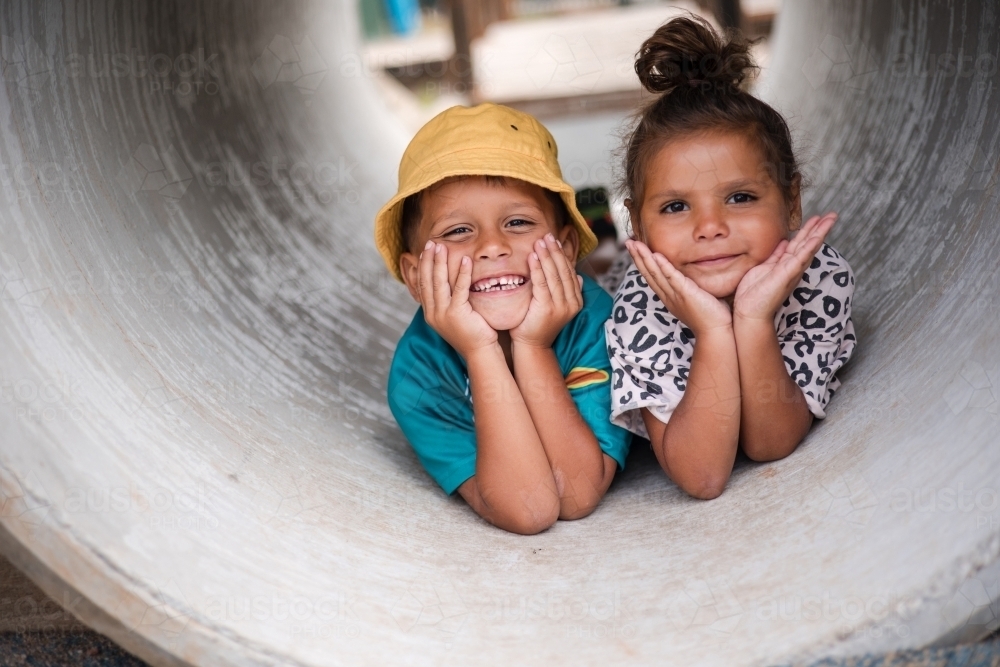 Young First Nations girl and boy playing together in a tunnel - Australian Stock Image