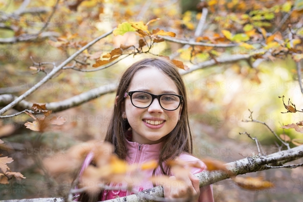 Young girl amongst tree branches - Australian Stock Image