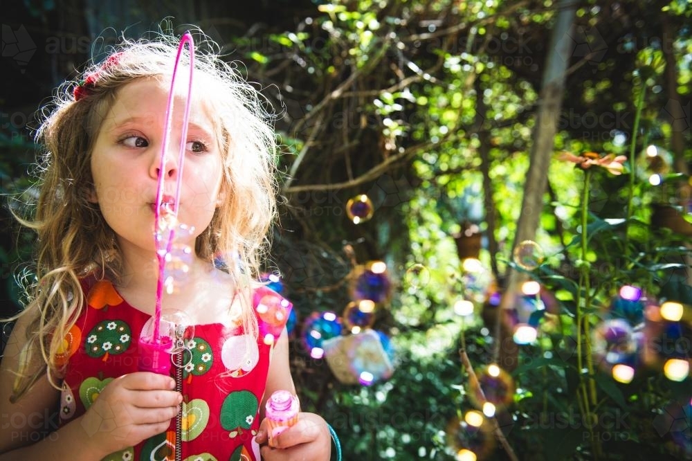 Young girl blowing bubbles - Australian Stock Image