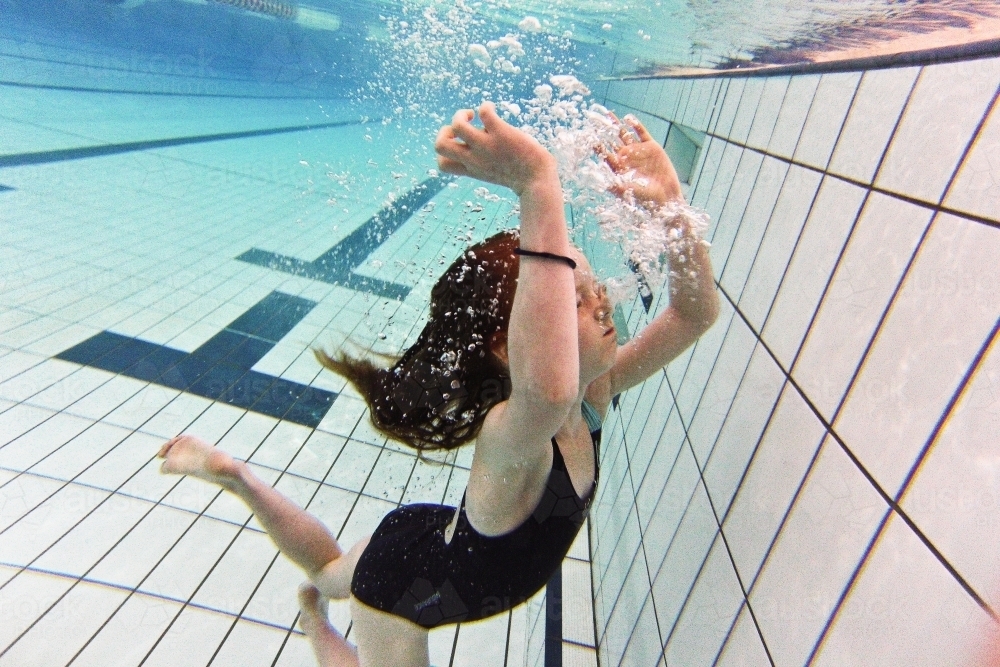 Young girl blowing bubbles underwater - Australian Stock Image