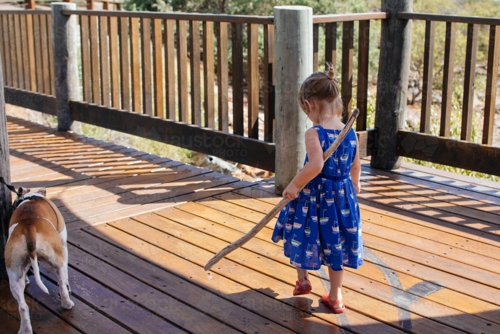 Young girl carrying a piece of drift wood - Australian Stock Image