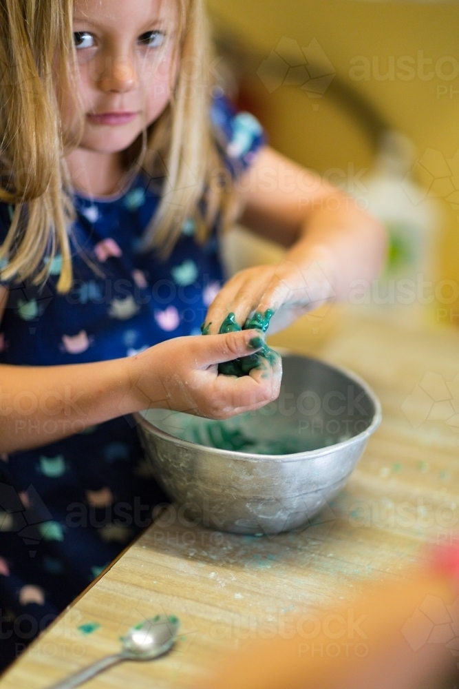 Young girl child mixing slime in a bowl - Australian Stock Image