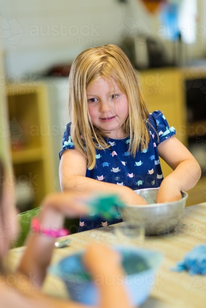Young girl child mixing slime in a bowl - Australian Stock Image