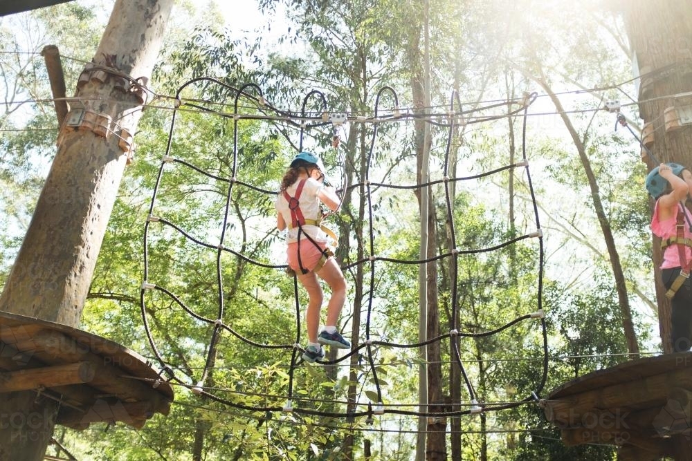 Young girl climbing a climbing frame at a park - Australian Stock Image