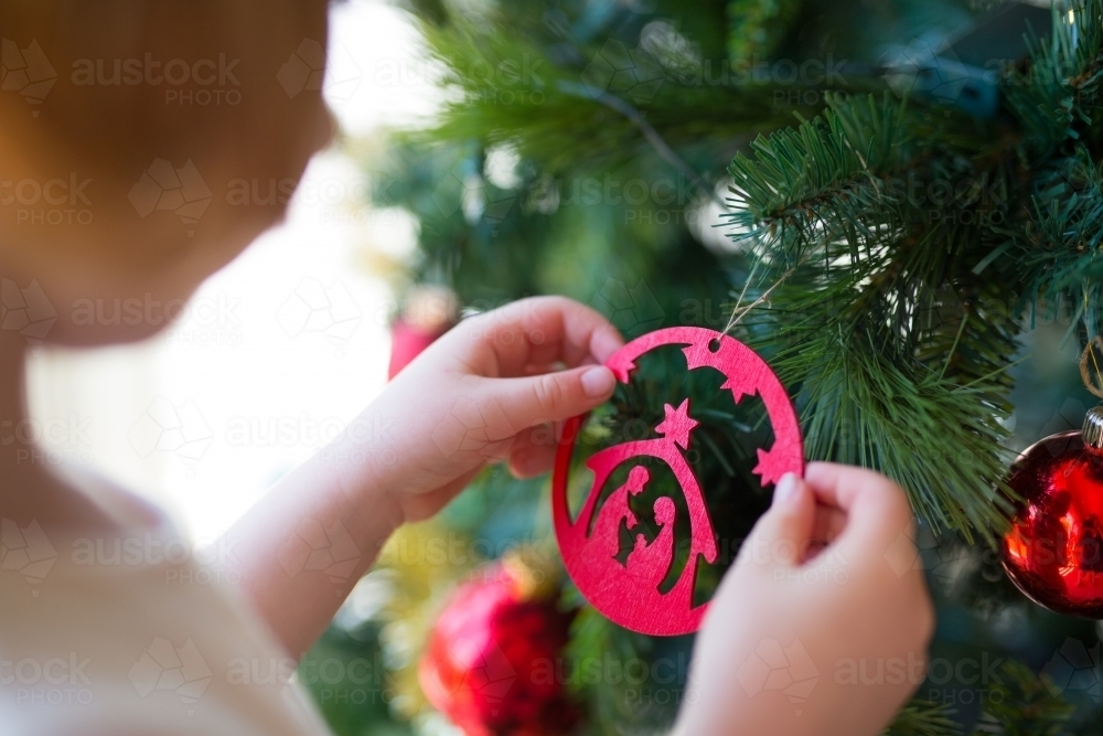 Young girl decorating a christmas tree - Australian Stock Image