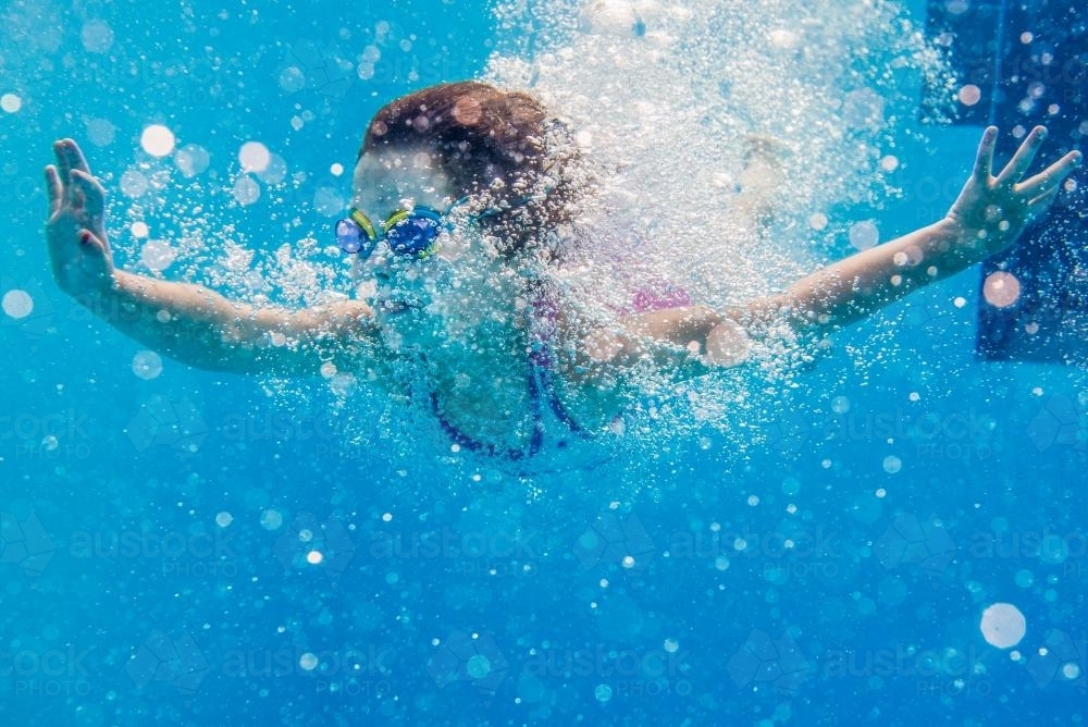 Young girl diving underwater - Australian Stock Image