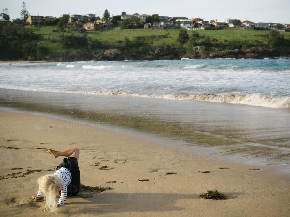 young girl doing yoga on the beach - Australian Stock Image