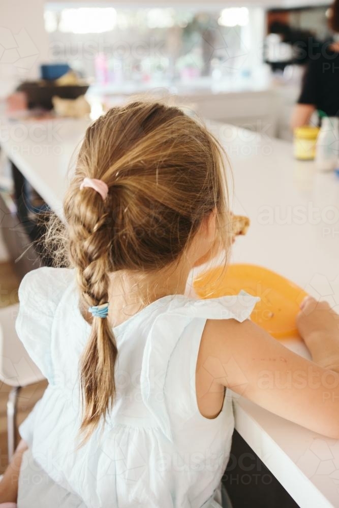 Young girl eating lunch at home in the kitchen - Australian Stock Image