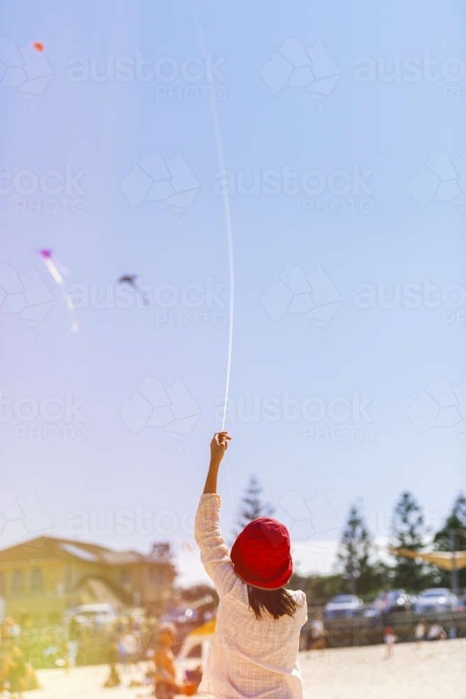 Young girl flying kite at beach - Australian Stock Image