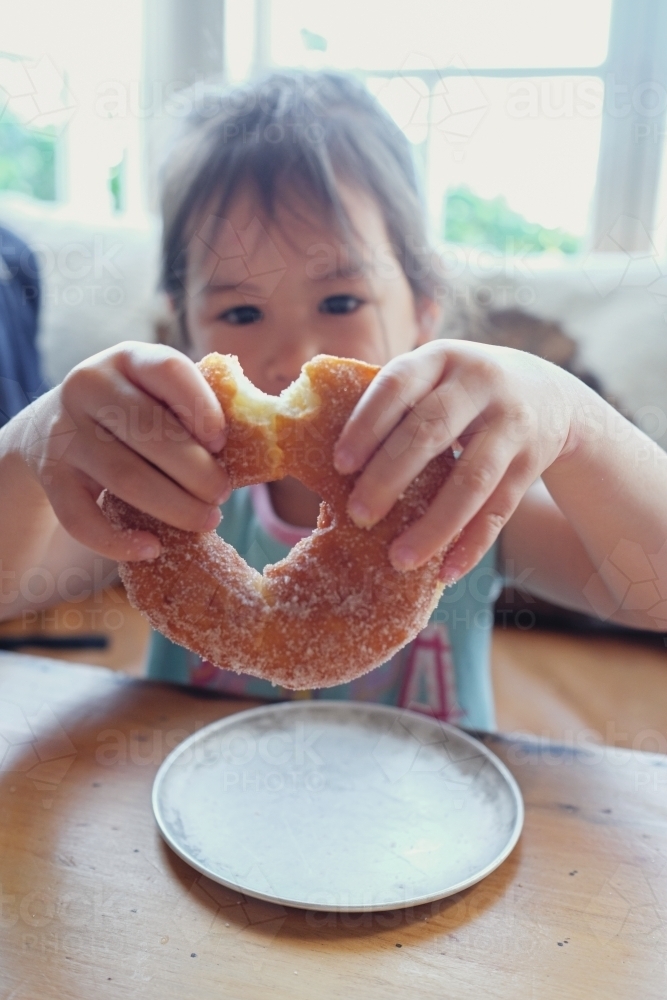 Young girl holding a doughnut - Australian Stock Image