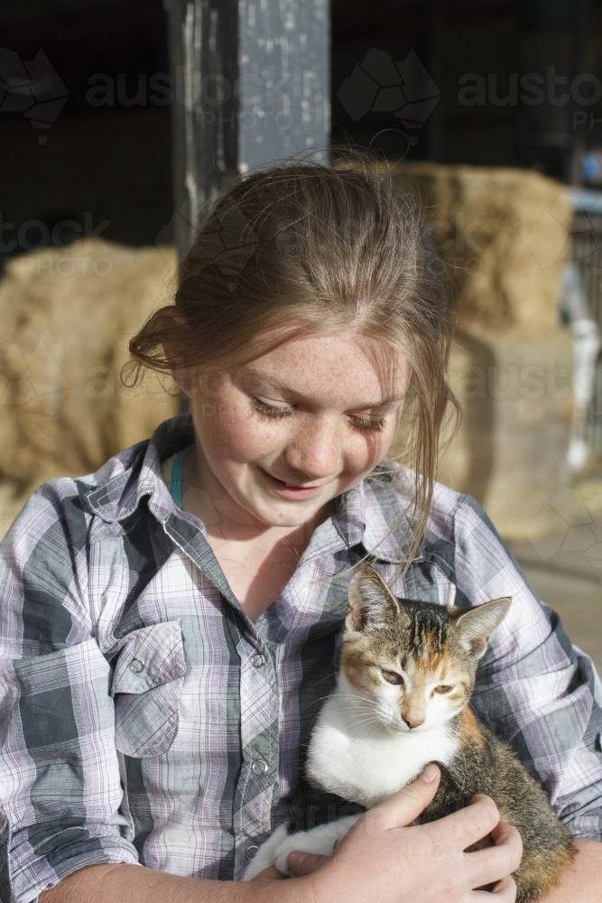Young girl holding a farm cat - Australian Stock Image