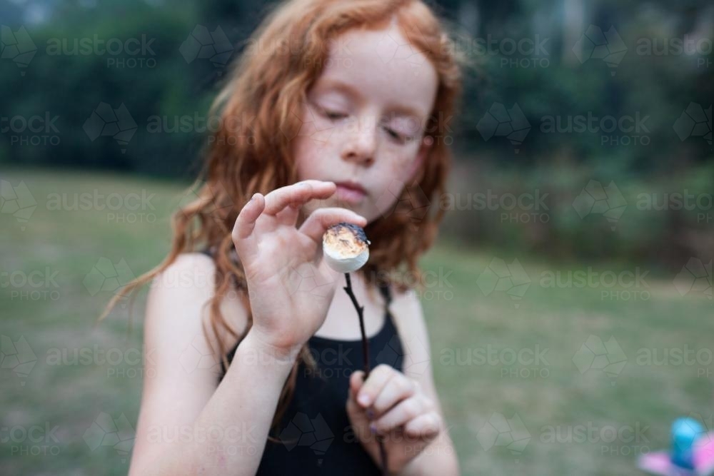 Young girl holding a marshmallow on a stick - Australian Stock Image