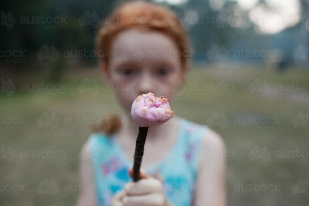Young girl holding a toasted marshmallow - Australian Stock Image
