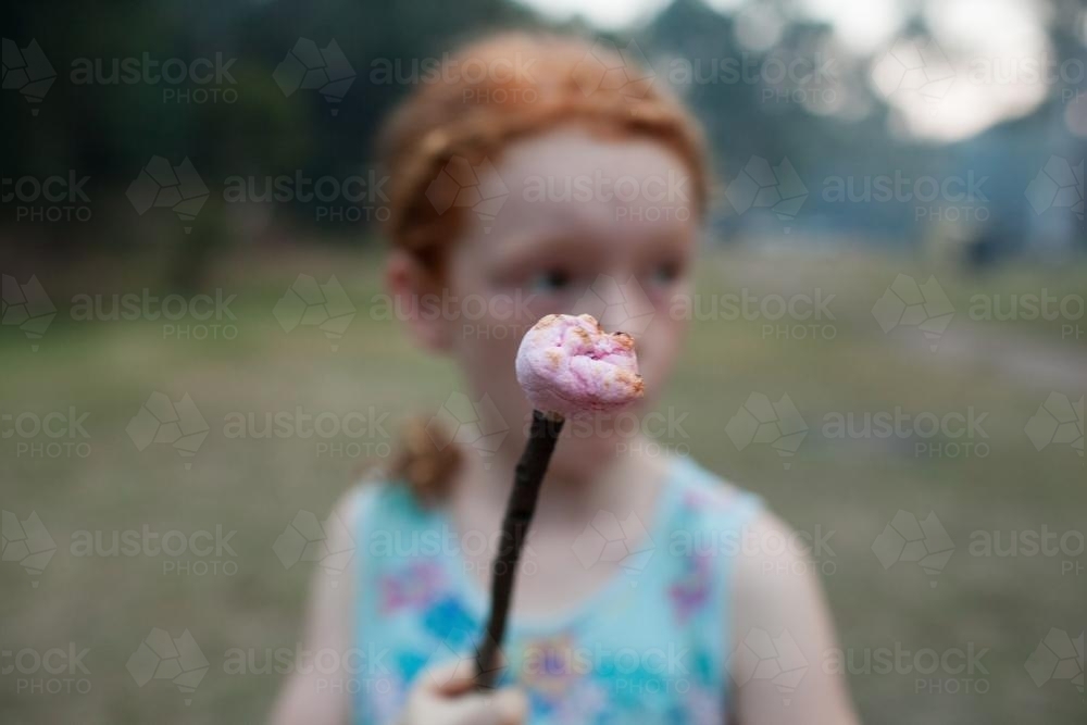 Young girl holding a toasted marshmallow - Australian Stock Image