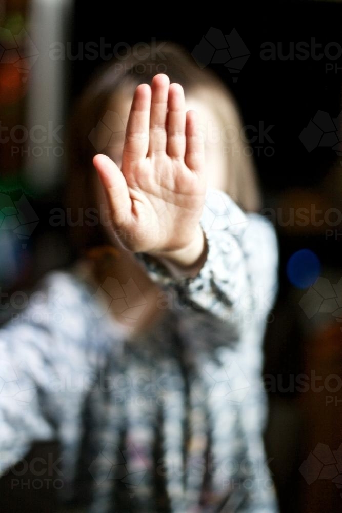 Young girl holding her hand up to the camera to say stop - Australian Stock Image