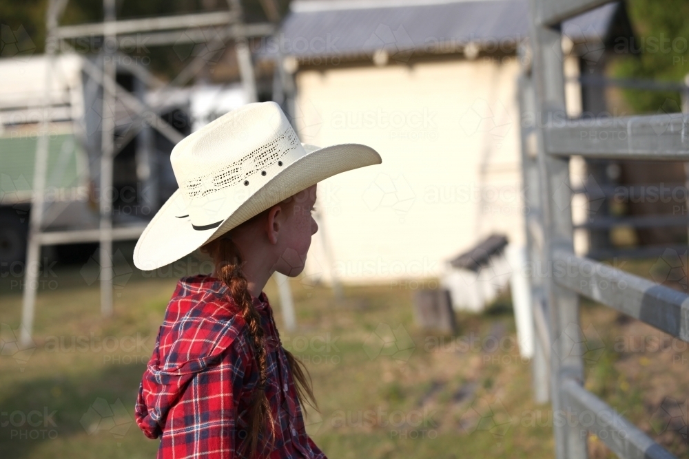 Young girl in a check shirt and cowboy hat - Australian Stock Image