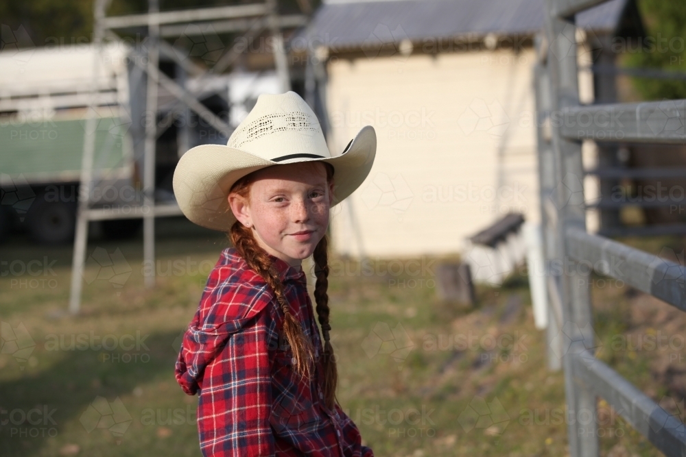 Young girl in a check shirt and cowboy hat - Australian Stock Image
