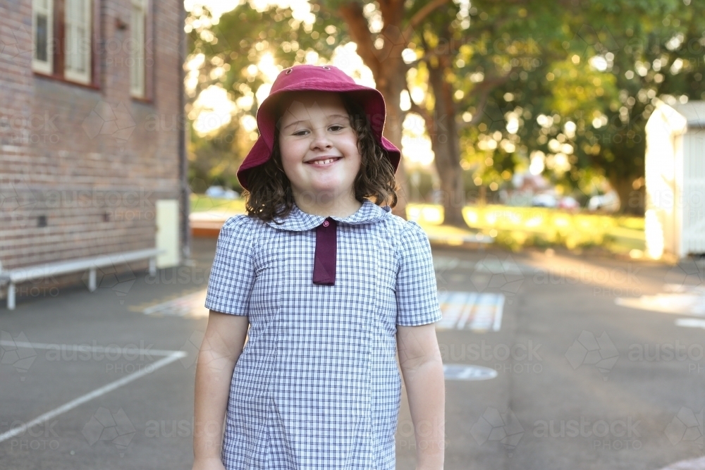 Image of Young girl in school uniform smiling in school playground ...